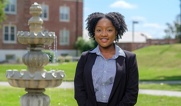 Woman wearing a suit in front of a fountain