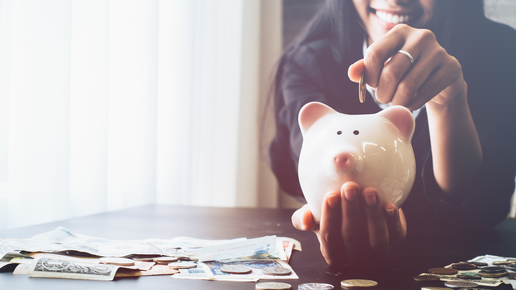 Woman putting money in a piggy bank
