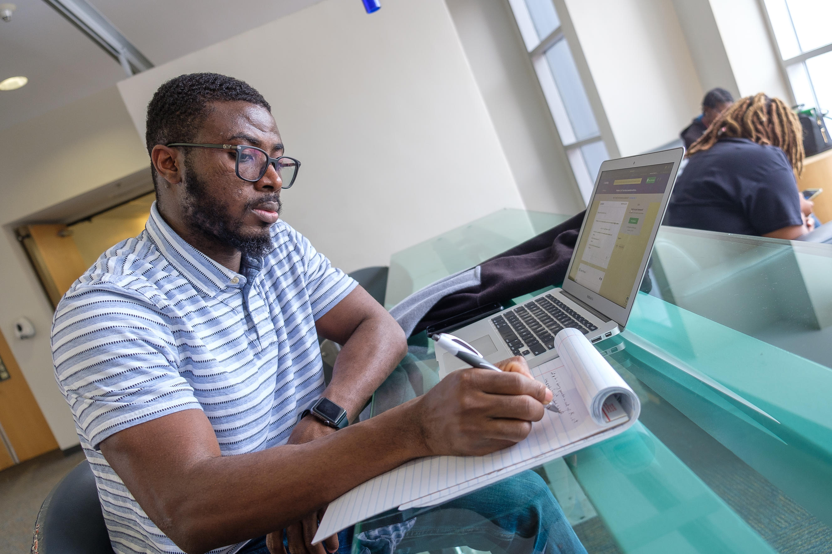 Student takes notes during online meeting