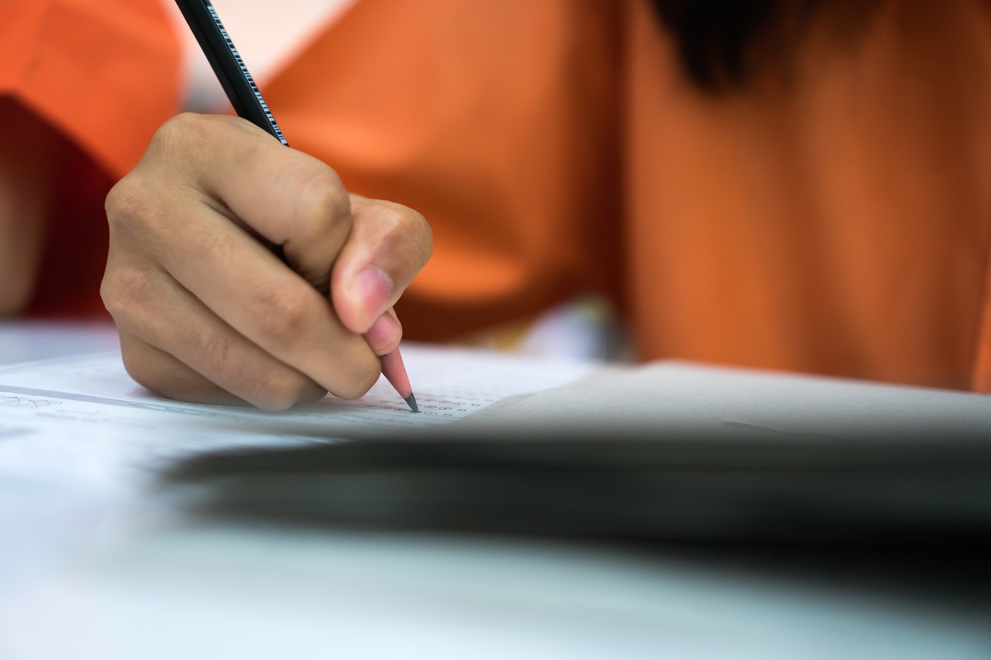 Student is taking survey on paper with pencil