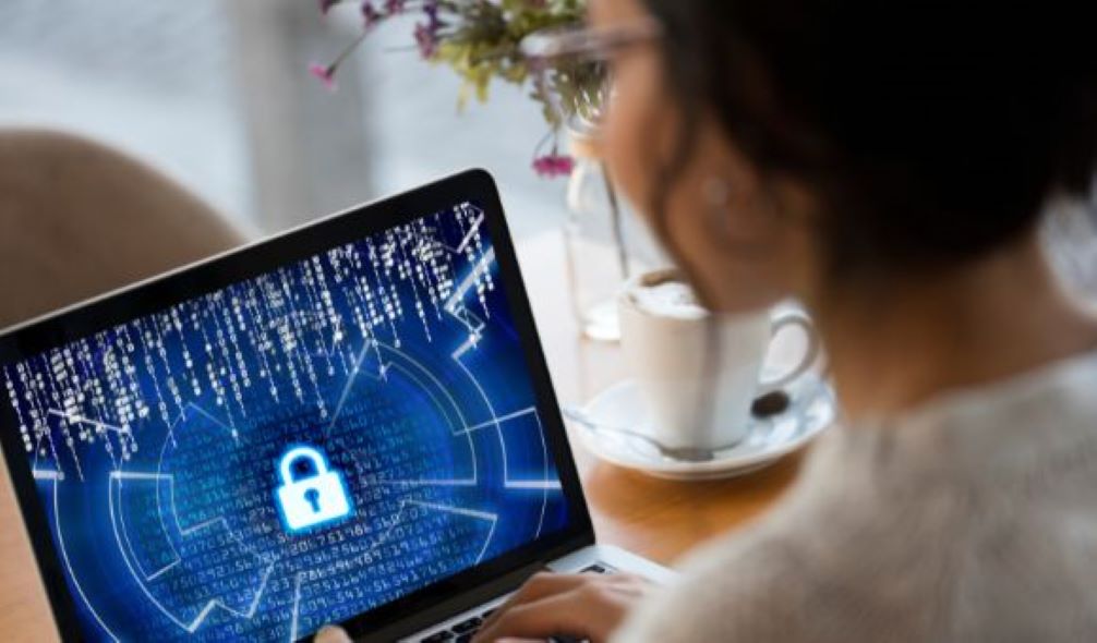 Woman looking at the cybersecurity icon on her laptop.