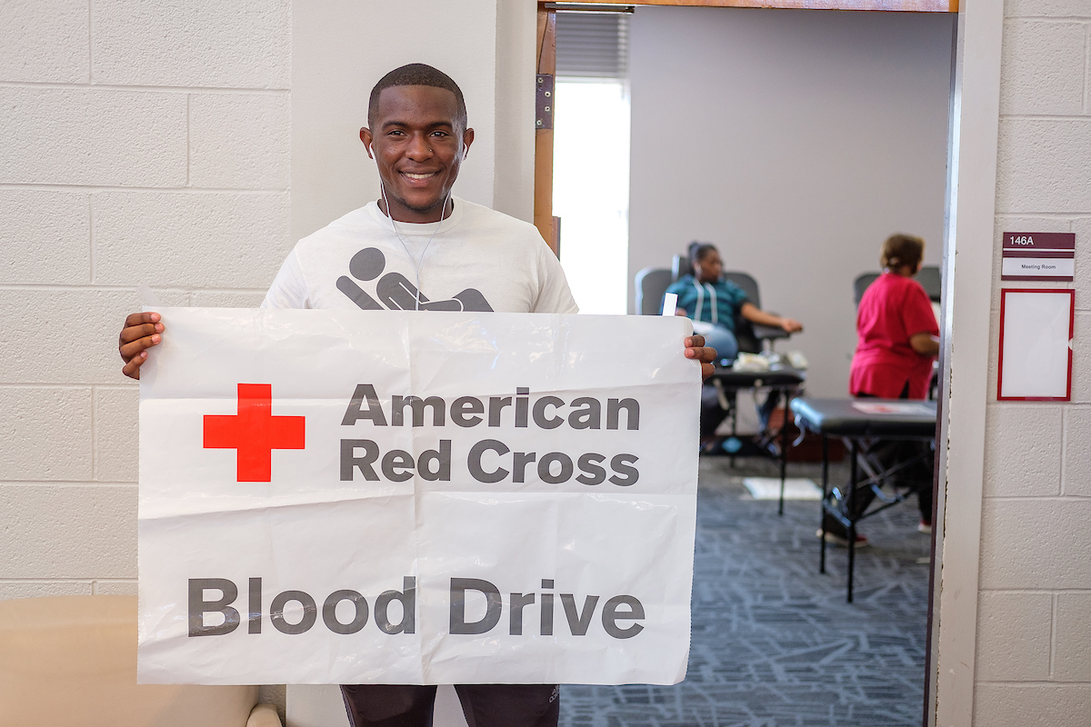 Student holding American Red Cross Sign