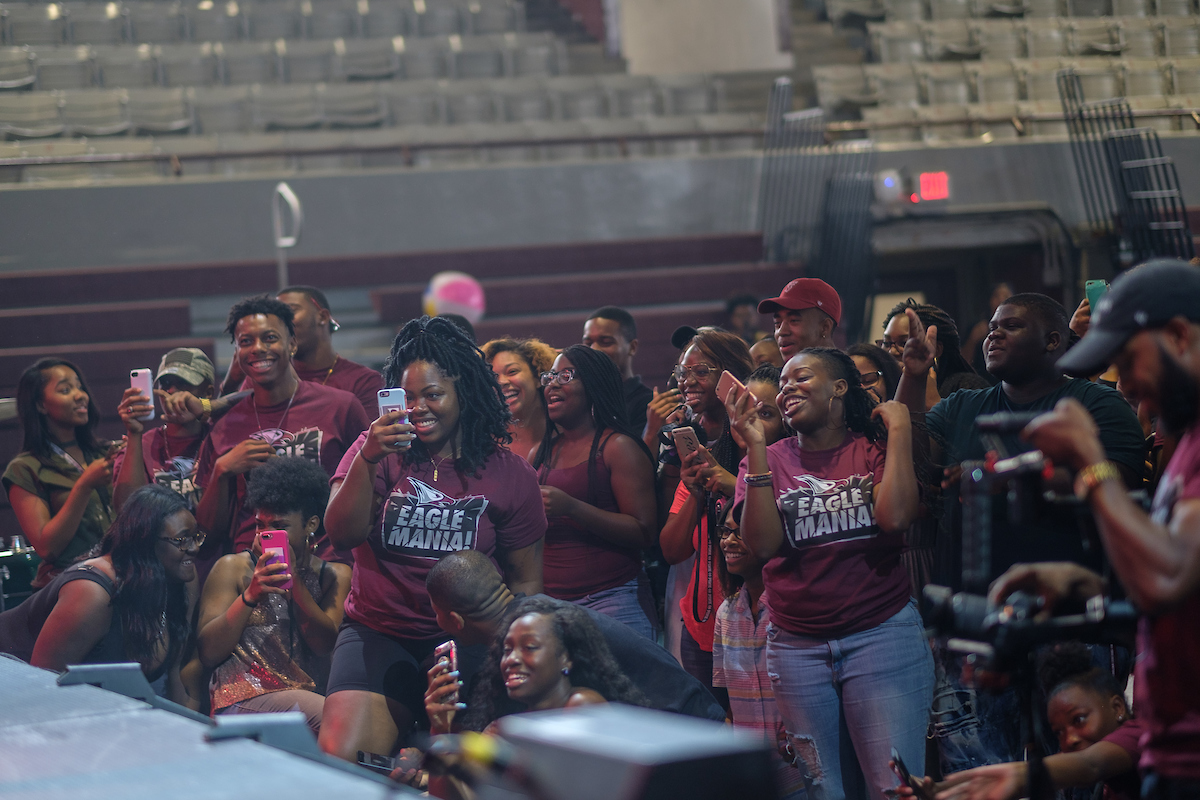 Students in a crowd, looking at stage. Participating in Eagle Mania
