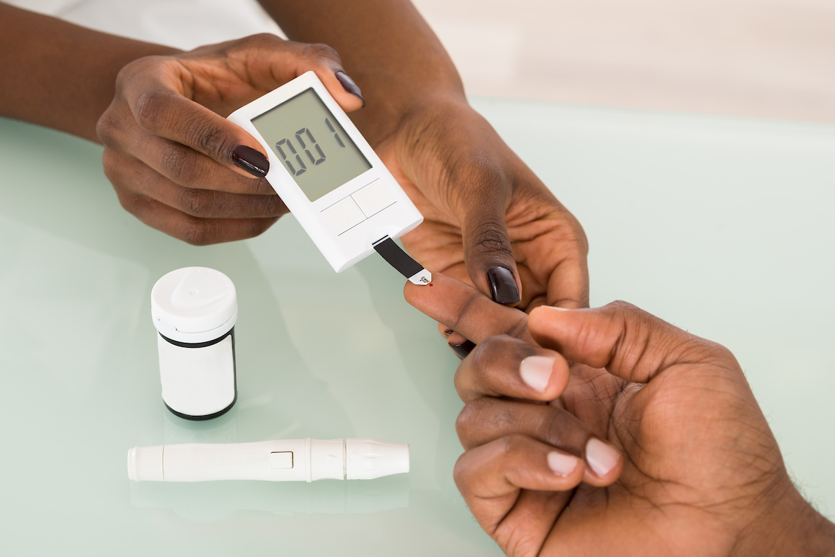 A stock image of a nurse administering a blood sugar test