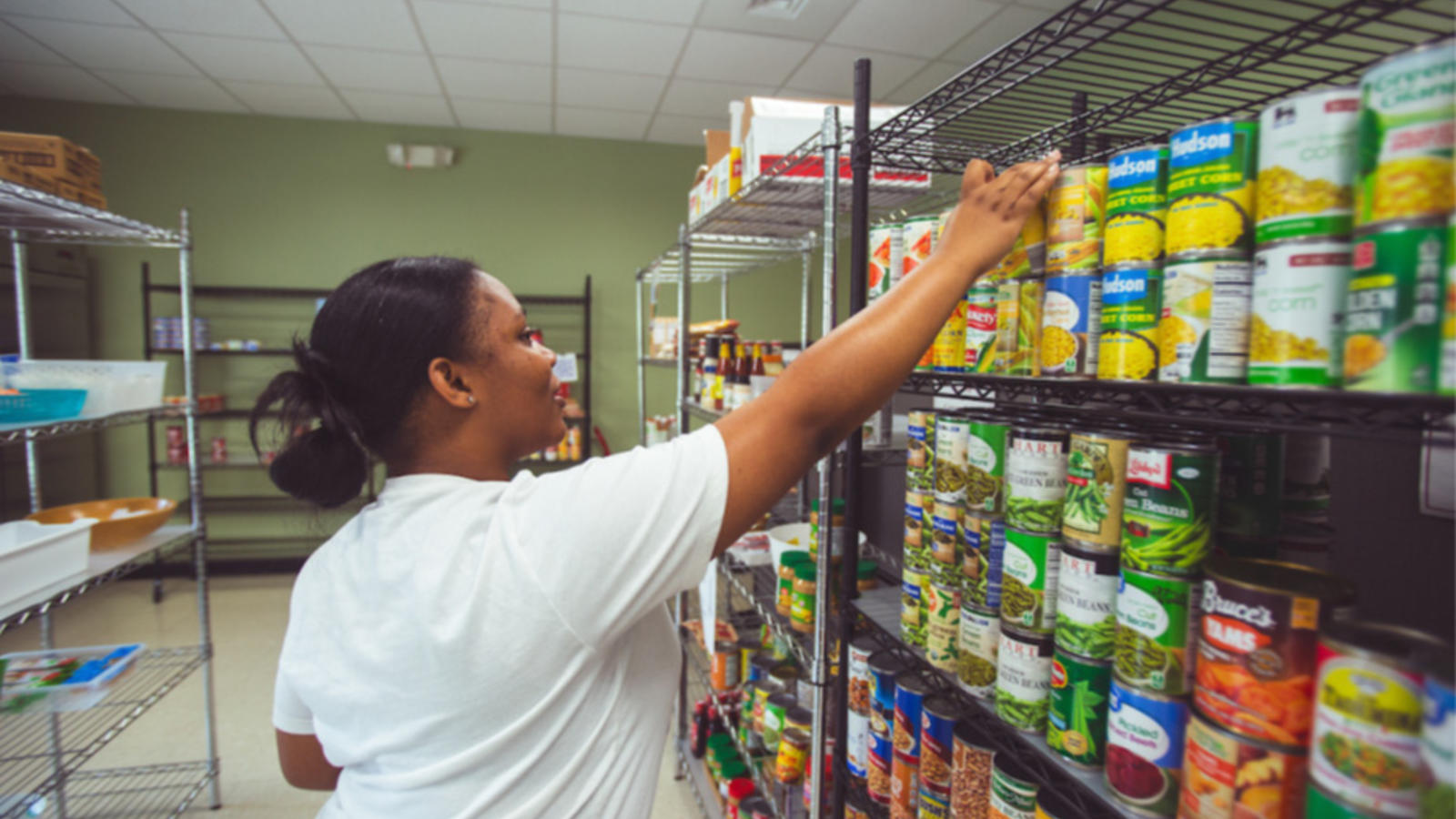 student placing canned food on a shelf