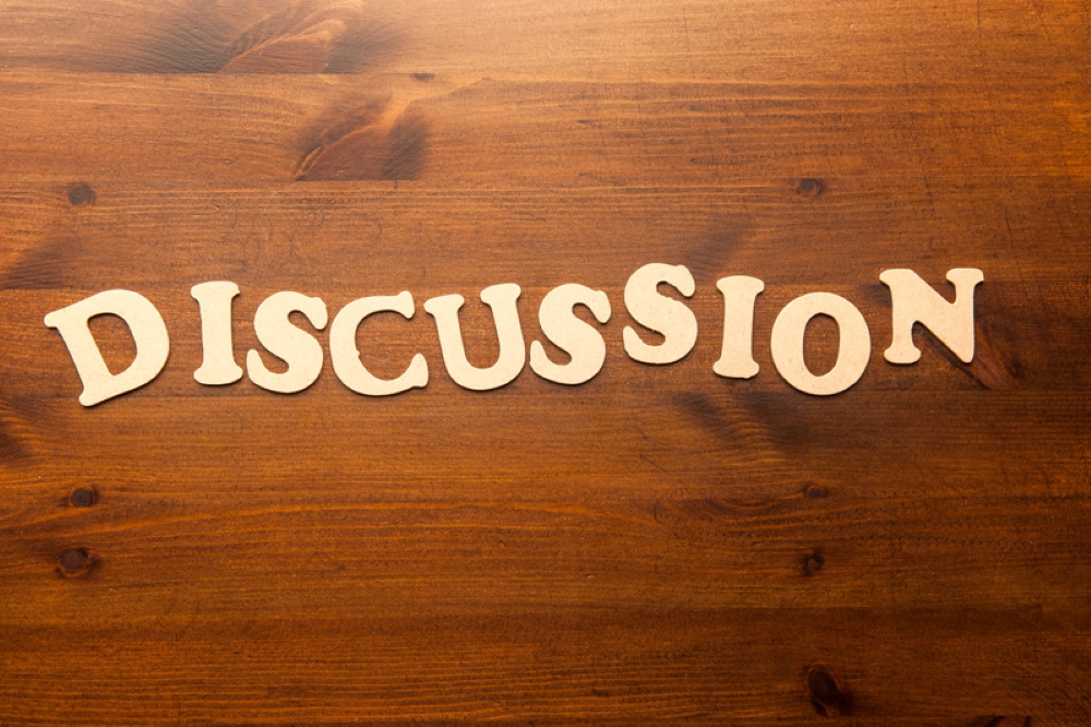 Discussion written with wood as backdrop