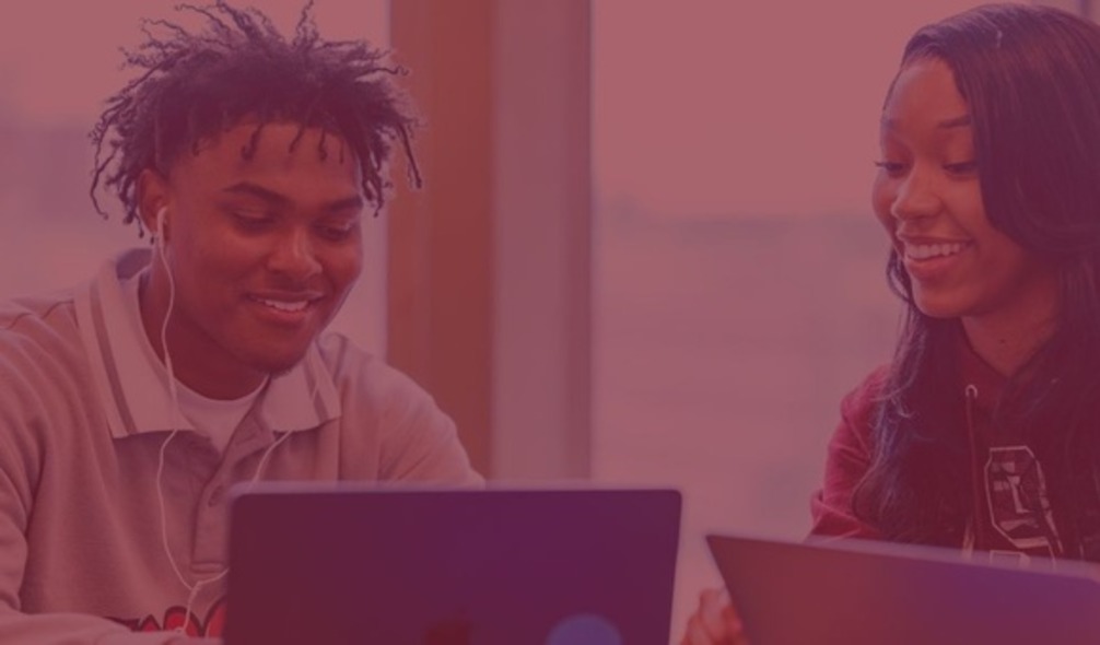Photo of two students looking at their laptops.