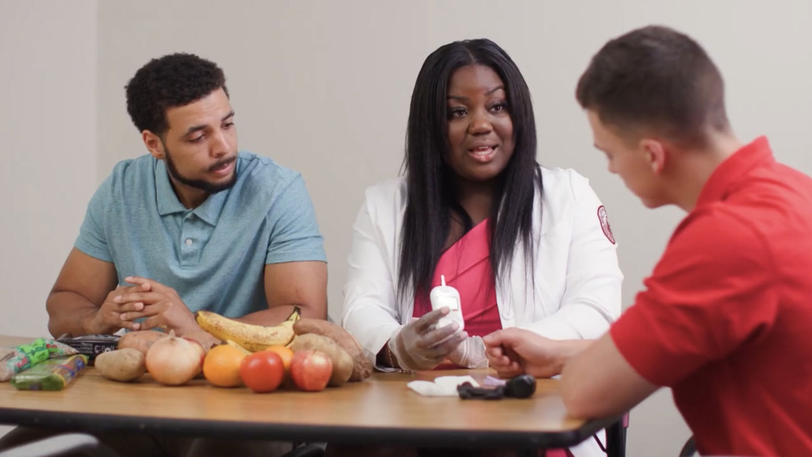 Three people conversing with food on the table