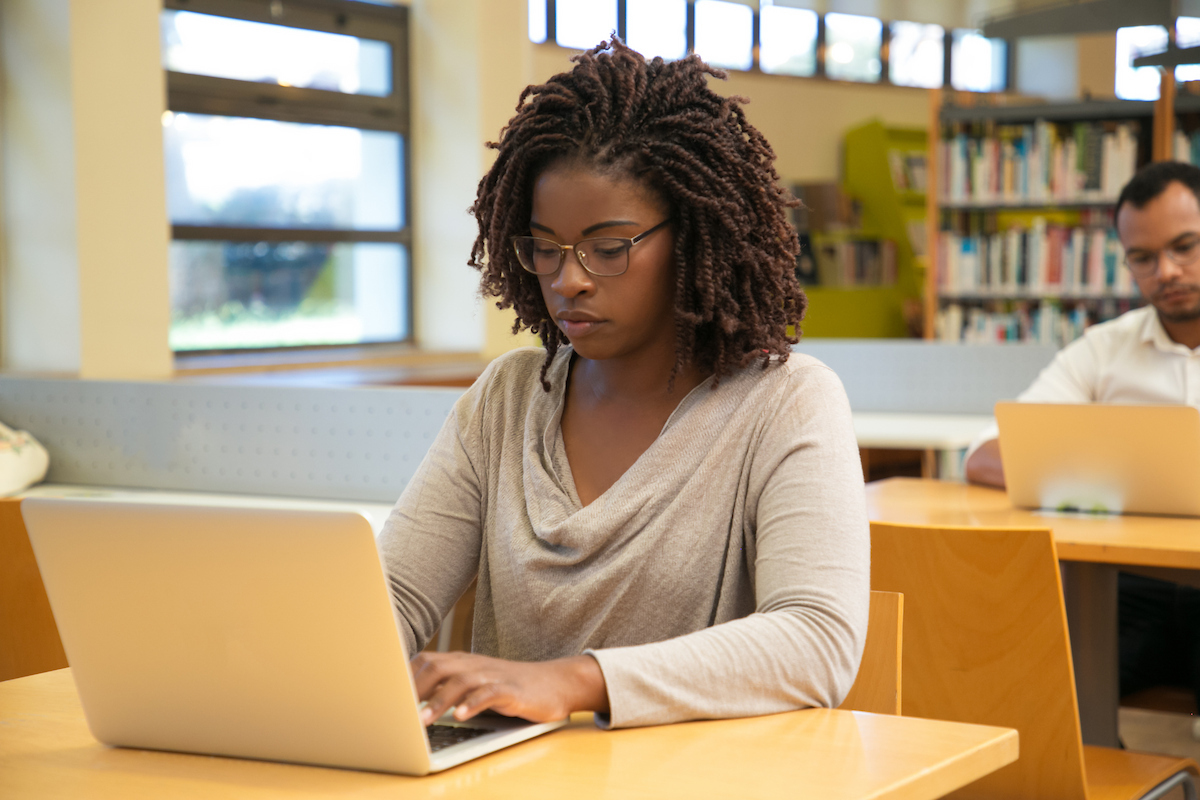 Student sitting at a desk and using a laptop