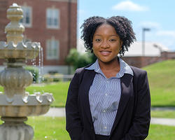 Woman wearing a suit in front of a fountain