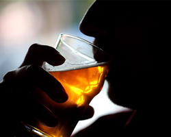 A person drinking a alcoholic beverage