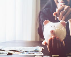 Woman putting money in a piggy bank
