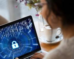 Woman looking at the cybersecurity icon on her laptop.