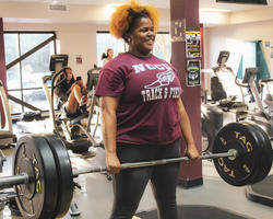 NCCU Student carrying dumbbell on Gym