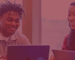 Photo of two students looking at their laptops.