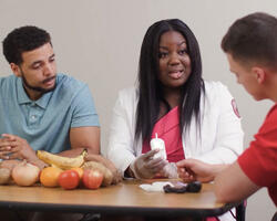 three people talking with food on table