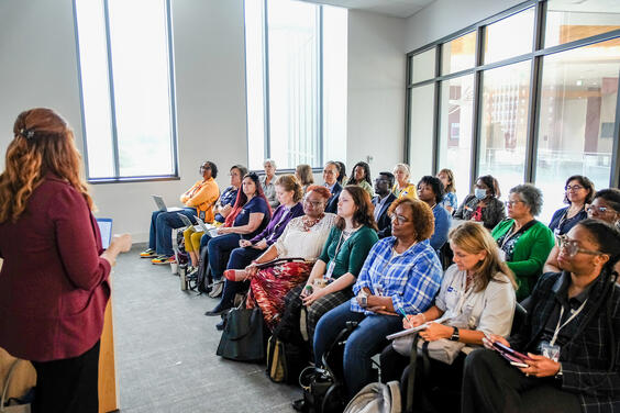 People sitting in a large group and listening to a speaker