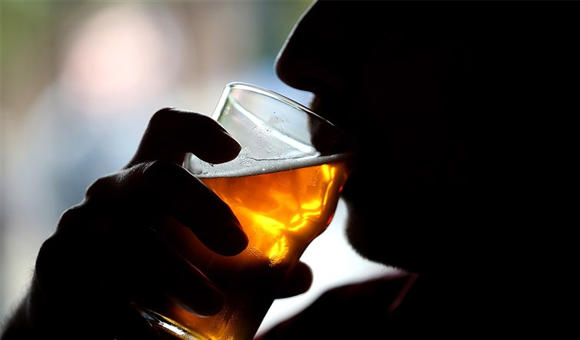 A person drinking a alcoholic beverage