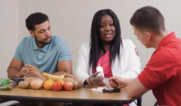 three people talking with food on table