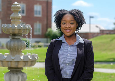 Woman wearing a suit in front of a fountain