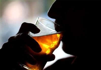 A person drinking a alcoholic beverage