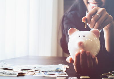 Woman putting money in a piggy bank
