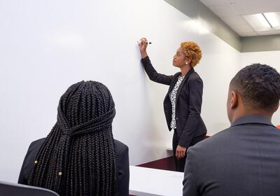 Business teacher is teaching in white board