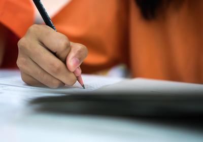 Student is taking survey on paper with pencil
