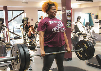 NCCU Student carrying dumbbell on Gym