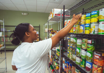 student placing canned food on a shelf