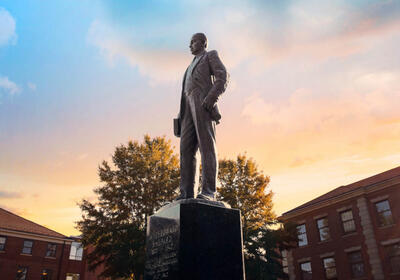 Shepard statue outside of NCCU with the sunset in the background