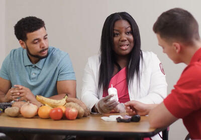 Three people conversing with food on the table