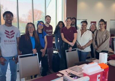 Group of people standing behind a table