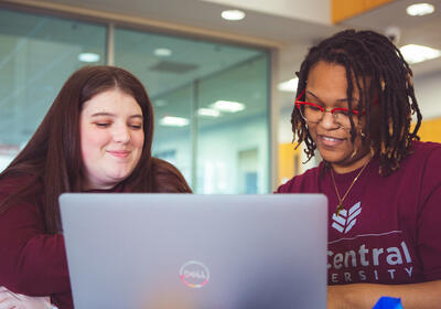 Two students looking at a laptop